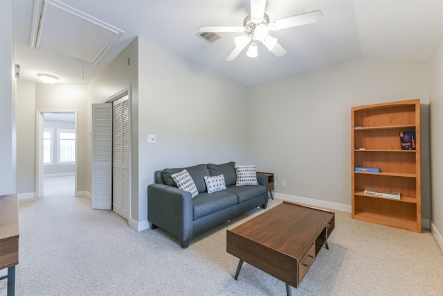 living area featuring lofted ceiling, baseboards, attic access, ceiling fan, and carpet flooring