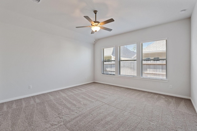 carpeted spare room with a ceiling fan and baseboards