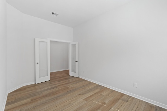 empty room with baseboards, visible vents, and light wood-style flooring