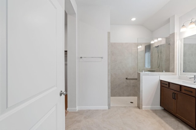 bathroom featuring baseboards, tile patterned flooring, vanity, and a walk in shower