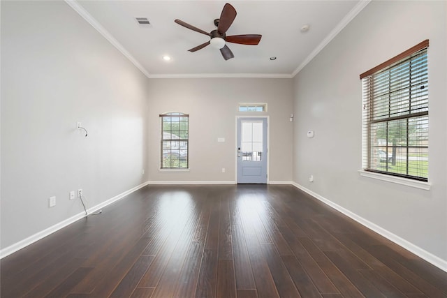 empty room featuring visible vents, ornamental molding, baseboards, ceiling fan, and dark wood finished floors
