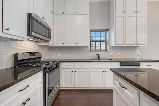 kitchen with a sink, tasteful backsplash, stainless steel appliances, and white cabinetry