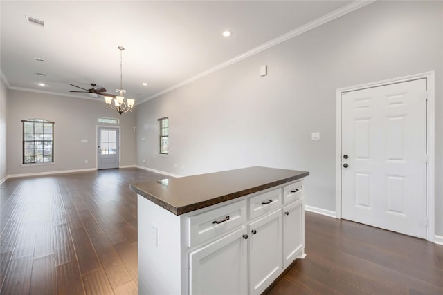 kitchen featuring visible vents, ornamental molding, a kitchen island, dark countertops, and recessed lighting