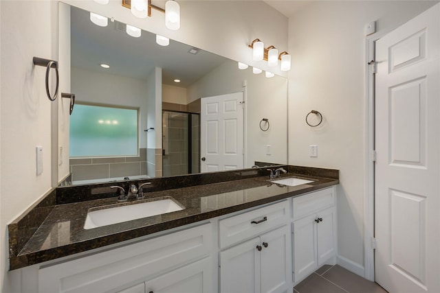 full bath featuring a sink, tile patterned flooring, a stall shower, and double vanity