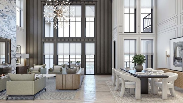 living room featuring light wood finished floors, a towering ceiling, and a wealth of natural light
