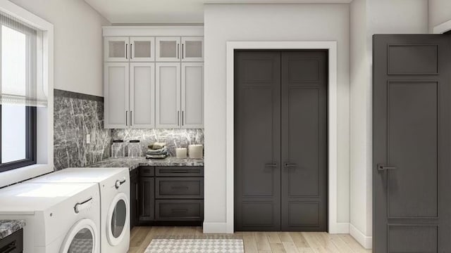 washroom featuring separate washer and dryer, plenty of natural light, light wood-style flooring, and cabinet space