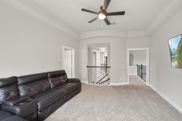 living room featuring carpet floors, a ceiling fan, visible vents, and baseboards