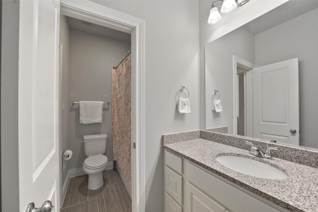 bathroom featuring tile patterned floors, vanity, baseboards, toilet, and visible vents