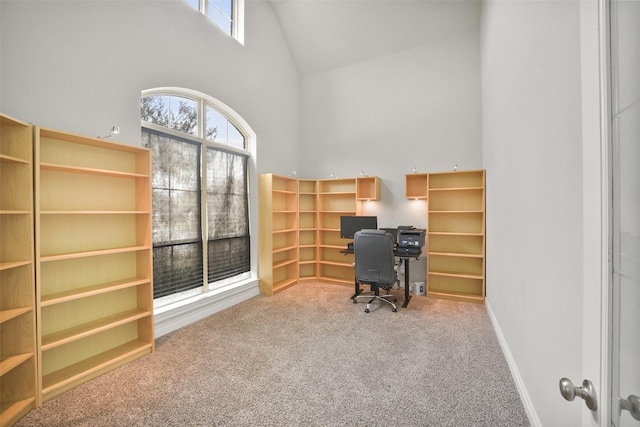 carpeted office with baseboards and high vaulted ceiling
