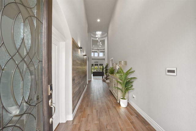 foyer with recessed lighting, wood finished floors, baseboards, and a notable chandelier
