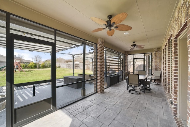 sunroom featuring ceiling fan, outdoor dining space, and plenty of natural light