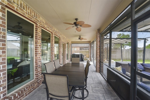 sunroom featuring a ceiling fan and outdoor dining space