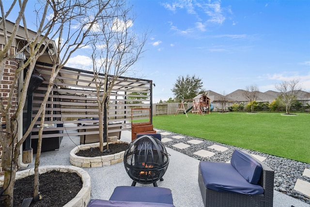view of patio / terrace with a playground, an outdoor fire pit, and fence