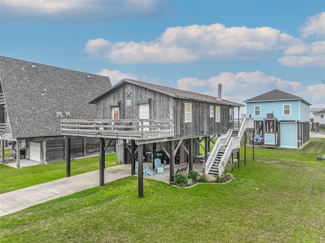 23001 Fresca St, Galveston, TX 77554 - rear view of house featuring a deck, stairway, driveway, and a yard