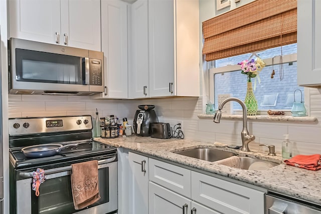 23001 Fresca St, Galveston, TX 77554 - kitchen with appliances with stainless steel finishes, a sink, decorative backsplash, and white cabinetry