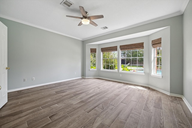 empty room with ceiling fan, ornamental molding, wood finished floors, and visible vents