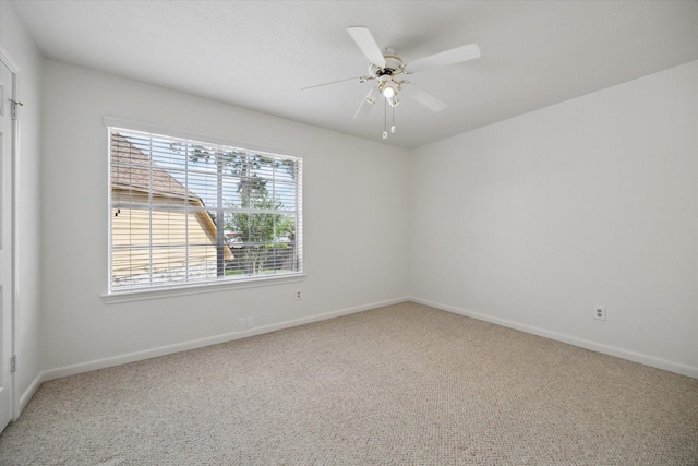 empty room featuring baseboards, a ceiling fan, and carpet