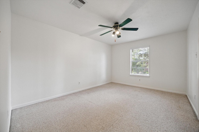 spare room with visible vents, a ceiling fan, baseboards, and carpet floors