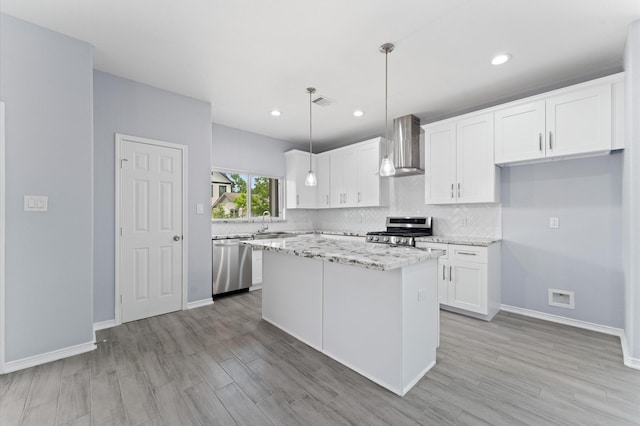 1215 E 34th St Unit A, Houston, TX 77022 - kitchen with stainless steel appliances, wall chimney range hood, white cabinetry, backsplash, and recessed lighting