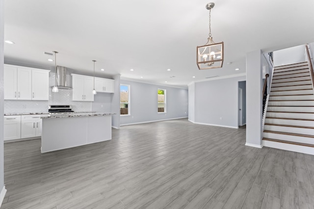 1215 E 34th St Unit A, Houston, TX 77022 - kitchen with wall chimney range hood, range, recessed lighting, white cabinetry, and decorative backsplash