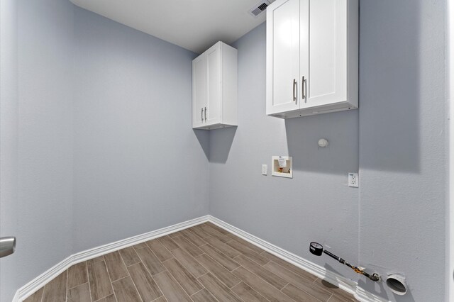 1215 E 34th St Unit A, Houston, TX 77022 - washroom with gas dryer hookup, washer hookup, wood finished floors, and cabinet space