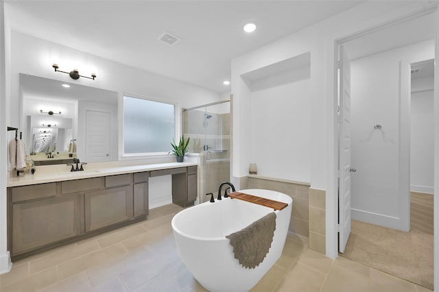 bathroom with a stall shower, a freestanding tub, vanity, tile patterned flooring, and visible vents