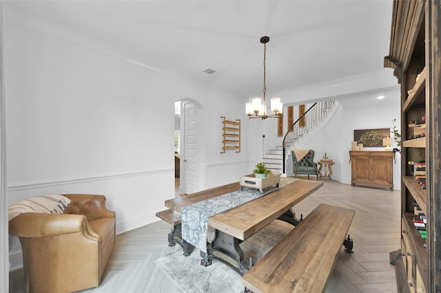 dining room with stairway, visible vents, arched walkways, baseboards, and a chandelier