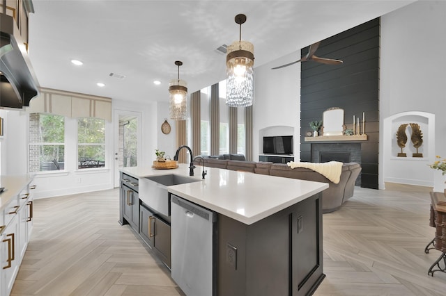 kitchen with recessed lighting, light countertops, dishwasher, a sink, and a fireplace