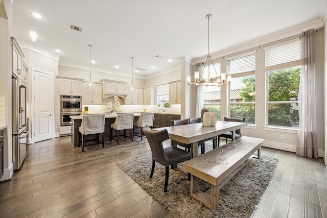dining room featuring plenty of natural light, ornamental molding, and a chandelier