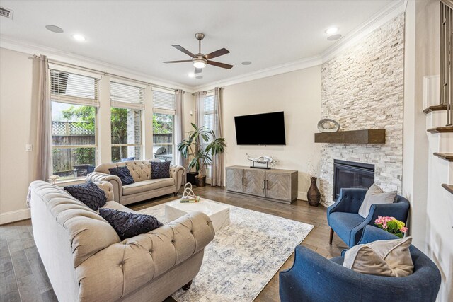 living room featuring ceiling fan, visible vents, crown molding, wood finished floors, and baseboards