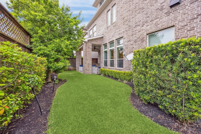 view of yard featuring fence and a ceiling fan