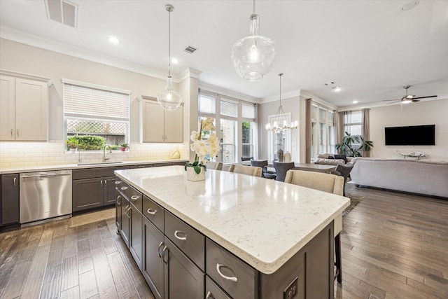 kitchen with a sink, decorative backsplash, stainless steel dishwasher, visible vents, and a kitchen island