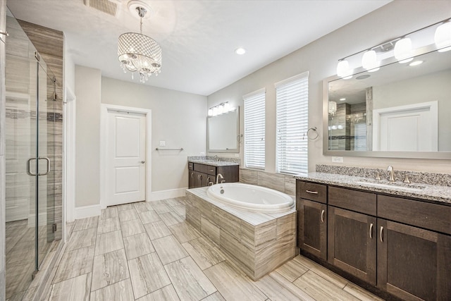 bathroom featuring visible vents, a sink, a garden tub, and a stall shower