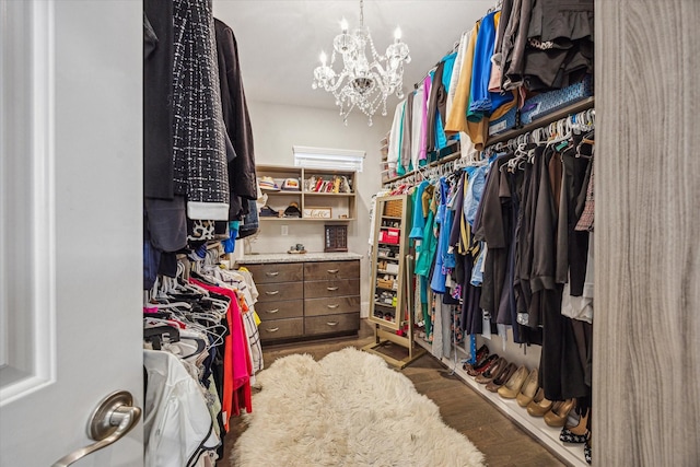 walk in closet featuring an inviting chandelier and wood finished floors