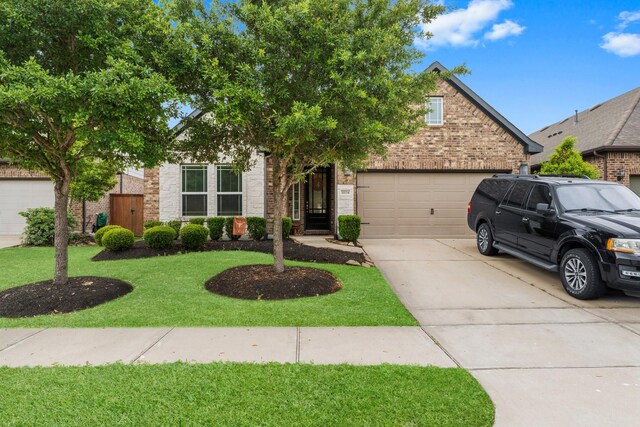11134 Honeysuckle Haven Dr, Cypress, TX 77433 - view of property hidden behind natural elements featuring an attached garage, driveway, stone siding, and a front yard