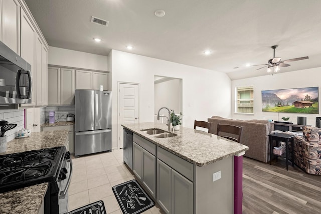 16231 Westley Ridge Dr, Hockley, TX 77447 - kitchen featuring stainless steel appliances, a sink, gray cabinetry, tasteful backsplash, and recessed lighting