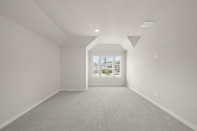 21806 Gateway Arch Dr, Porter, TX 77365 - bonus room featuring light carpet, vaulted ceiling, and a textured ceiling