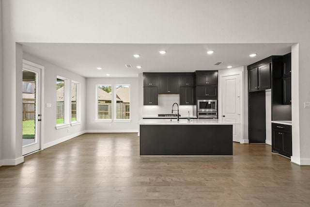 21806 Gateway Arch Dr, Porter, TX 77365 - kitchen with appliances with stainless steel finishes, light countertops, dark cabinets, recessed lighting, and wood finished floors