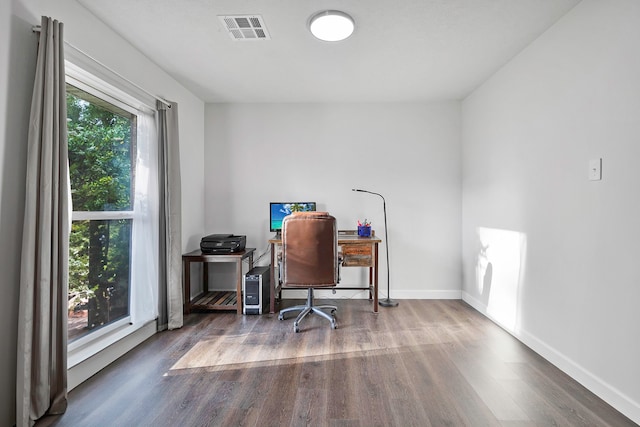 home office with wood finished floors, visible vents, and baseboards