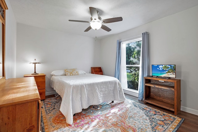 bedroom with baseboards, a ceiling fan, and wood finished floors