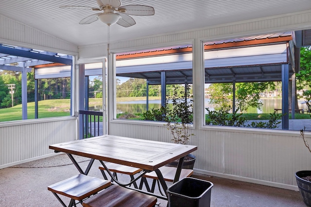 sunroom / solarium featuring a wealth of natural light, a ceiling fan, and a water view