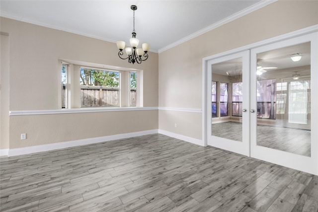 spare room featuring baseboards, ornamental molding, french doors, and wood finished floors