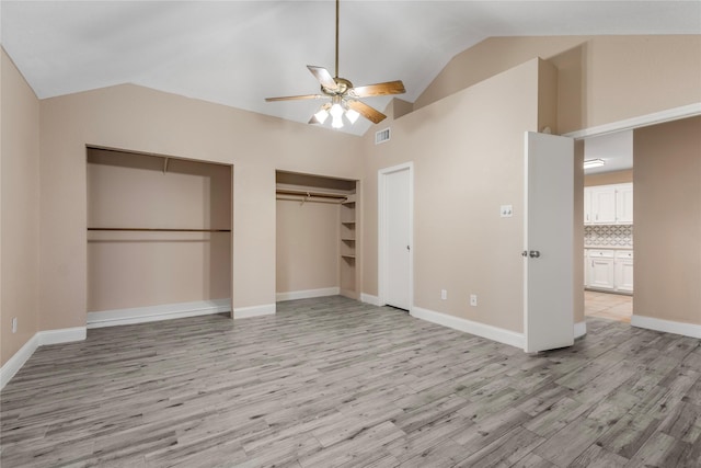 unfurnished bedroom featuring light wood-style floors, two closets, visible vents, and baseboards