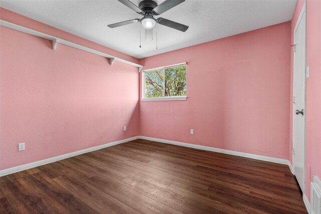 unfurnished room featuring a ceiling fan, baseboards, and dark wood-style flooring