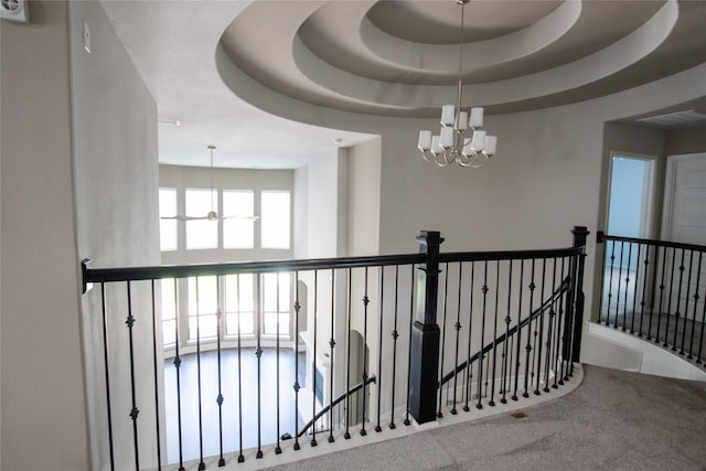 hallway featuring carpet floors, visible vents, an inviting chandelier, and an upstairs landing