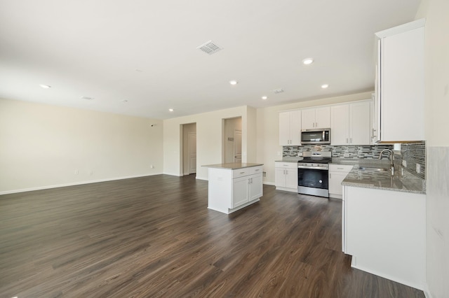 kitchen with a center island, a sink, open floor plan, visible vents, and appliances with stainless steel finishes