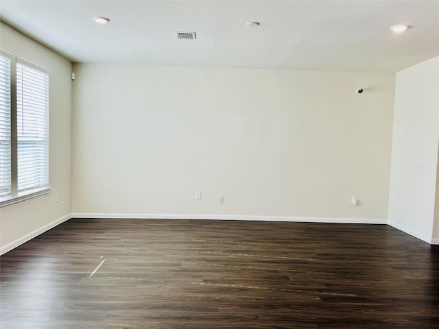 empty room featuring baseboards, recessed lighting, visible vents, and dark wood-type flooring