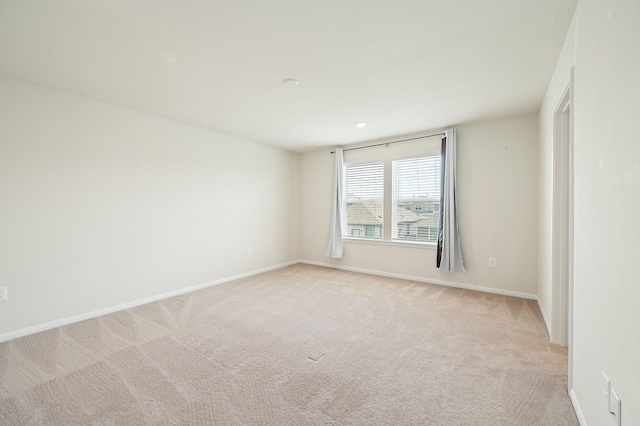 empty room with baseboards and light colored carpet