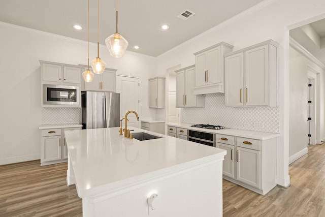 10021 Preserve Way, Conroe, TX 77385 - kitchen with appliances with stainless steel finishes, a sink, decorative backsplash, ornamental molding, and light wood finished floors