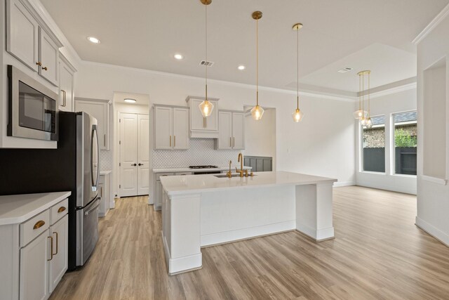 10021 Preserve Way, Conroe, TX 77385 - kitchen featuring appliances with stainless steel finishes, light wood-style flooring, light countertops, backsplash, and a sink